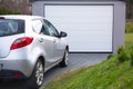 Free-standing garage in the garden with a car parked in front of the gate