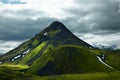 Free standing volcanic mountain covered with green moss