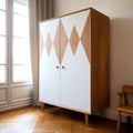 Free standing wooden wardrobe with white doors decorated with wooden shapes. Scandinavian style interior design of modern bedroom