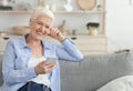 Free Time Leisure. Cheerful Aged Woman Litening Music On Smartphone At Home