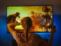 Free time, leisure, watching your favorite TV series. A young woman is sitting in front of the TV and emotionally watching a movie