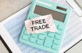 FREE TRADE text, written on a sticker with calculator,pen on chart background Royalty Free Stock Photo