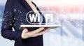 Free WiFi network signal technology internet concept. Hand hold white tablet with digital hologram Wi Fi sign on light blurred Royalty Free Stock Photo