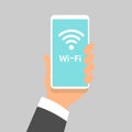 Free wifi sign concept. Hand holding mobile phone with free wifi text and wifi symbol on the display. Flat design Royalty Free Stock Photo