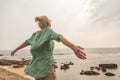 Free woman enjoying windy weather on beach on overcast day Royalty Free Stock Photo