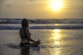 Free woman sitting looking to sea sunset practicing yoga and meditation at beautiful Asian beach Royalty Free Stock Photo