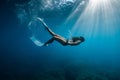 Freediver with fins posing underwater. Freediving with sporty girl in blue sea