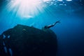 Freediver girl in pink swimwear with fins swimming underwater at wreck ship. Freediving in ocean Royalty Free Stock Photo