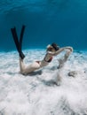 Freediver lady in bikini with sand in hands over sandy bottom. Freediving in tropical blue ocean with attractive woman Royalty Free Stock Photo