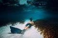 Freediver man with freediving fins relax over sandy bottom in blue sea