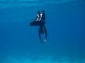 Freediver with monofin makes turn near sea bottom