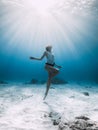 Freediver underwater. Freediving with woman in blue ocean with sandy bottom and sun rays Royalty Free Stock Photo