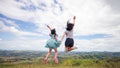 Freedom active daughter and mother jumping at the top of mountain.16:9 style