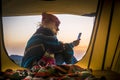 Freedom and adventure travel vacation alternative leisure activity lifestyle with woman sit down inside a tent with mountains and Royalty Free Stock Photo