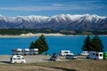 Freedom camp with campervans with blue Lake Pukaki and snow covered mountains in the background, South Island, New