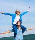 Freedom concept. Couple in love enjoy feeling freedom outdoor sunny day. Man carries girlfriend on shoulders, sky