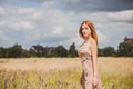 Freedom concept, elegant woman in long beige romantic dress at the field