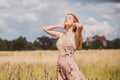 Freedom concept, elegant woman in long beige romantic dress at the field