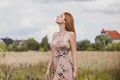 Freedom concept, elegant woman in long beige romantic dress at the field