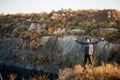 Freedom concept. Free man in sweater and black hat with open arms on sunset admire nature view of autumn lake Royalty Free Stock Photo