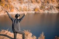 Freedom concept. Free man in sweater and black hat with open arms on sunset admire nature view of autumn lake. success. Travel. Royalty Free Stock Photo