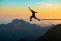 Freedom concept, Silhouette of a man jumping and broken chains at mountain with sunset sky.