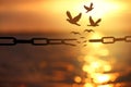 Freedom. Silhouettes of broken chain and birds flying over sea at sunset Royalty Free Stock Photo