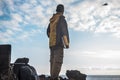 Freedom feeling and adventure time traveling for male in outdoor clothes looking at the ocean. horizon and blue sky in front of Royalty Free Stock Photo