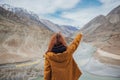Happy young woman traveler pointing to the mountain enjoy the beautiful view at confluence of zanskar and indus rivers in leh. Royalty Free Stock Photo