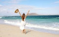 Freedom happy girl enjoying wind with raised arms and people kitesurfering, Corralejo Dunes beach, Fuerteventura, Canary Islands Royalty Free Stock Photo