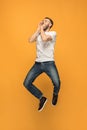 Freedom in moving. handsome young man jumping against orange background Royalty Free Stock Photo