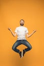 Freedom in moving. handsome young man jumping against orange background Royalty Free Stock Photo