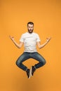 Freedom in moving. handsome young man jumping against orange background Royalty Free Stock Photo