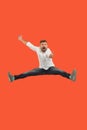 Freedom in moving. handsome young man jumping against orange background Royalty Free Stock Photo