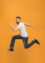 Freedom in moving. handsome young man jumping against orange background Royalty Free Stock Photo