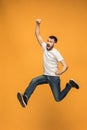 Freedom in moving. handsome young man jumping against orange background Royalty Free Stock Photo