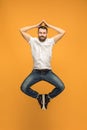 Freedom in moving. handsome young man jumping against orange background Royalty Free Stock Photo