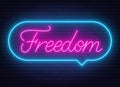 Freedom neon sign in the speech bubble on brick wall background. Royalty Free Stock Photo