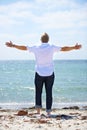 The freedom of retirement. Rear view of a senior man with his arms outstretched on the beach. Royalty Free Stock Photo