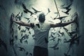 Freedom symbol: silhouette of a man with outstretched arms as birds fly away from chains Royalty Free Stock Photo