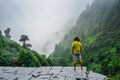 Freedom. Traveler on the edge of a cliff among the jungle and mountains