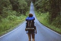 Freedom traveler woman standing with raised arms and enjoying a beautiful nature On a country road. woman with backpack travel In Royalty Free Stock Photo