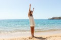 Freedom woman in free happiness bliss on beach. Smiling happy girl in white summer dress in vacation outdoors