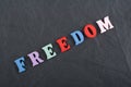 FREEDOM word on black board background composed from colorful abc alphabet block wooden letters, copy space for ad text. Learning Royalty Free Stock Photo