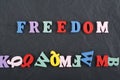 FREEDOM word on black board background composed from colorful abc alphabet block wooden letters, copy space for ad text Royalty Free Stock Photo