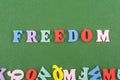 FREEDOM word on green background composed from colorful abc alphabet block wooden letters, copy space for ad text. Learning Royalty Free Stock Photo