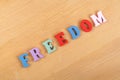 FREEDOM word on wooden background composed from colorful abc alphabet block wooden letters, copy space for ad text Royalty Free Stock Photo