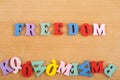 FREEDOM word on wooden background composed from colorful abc alphabet block wooden letters, copy space for ad text. Learning Royalty Free Stock Photo