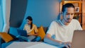 Freelance asia couple man and woman in casual feel serious focus on work separate laptop computer at night, hasband sit in front Royalty Free Stock Photo