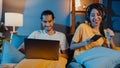 Freelance asia couple man and woman in casual hasband work laptop computer at night enjoy happy relax with wife wear headphone